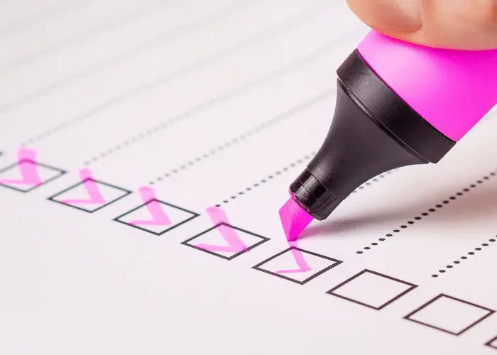 estudiante tachando de su checklist con un subrayador rosa los proyectos que ha realizado