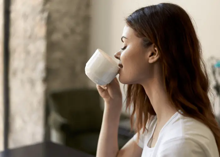 Joven mujer practicando mindfullness bebiendo una taza de té